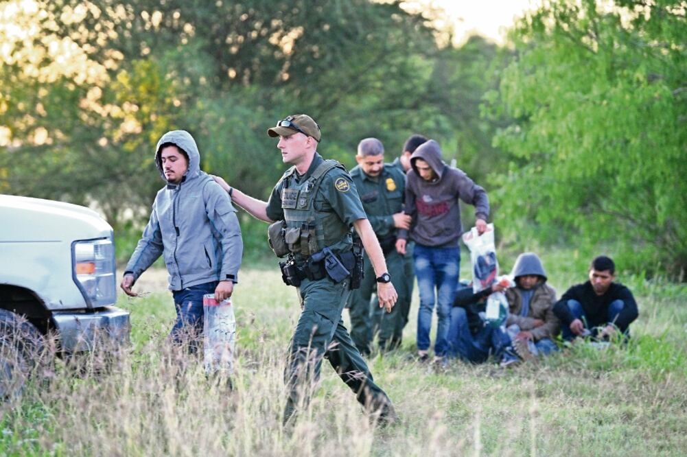 Agentes de la Patrulla Fronteriza al detener ayer a indocumentados, en la ciudad de Mission, en Texas. Foto: LOREN ELLIOTT. REUTERS