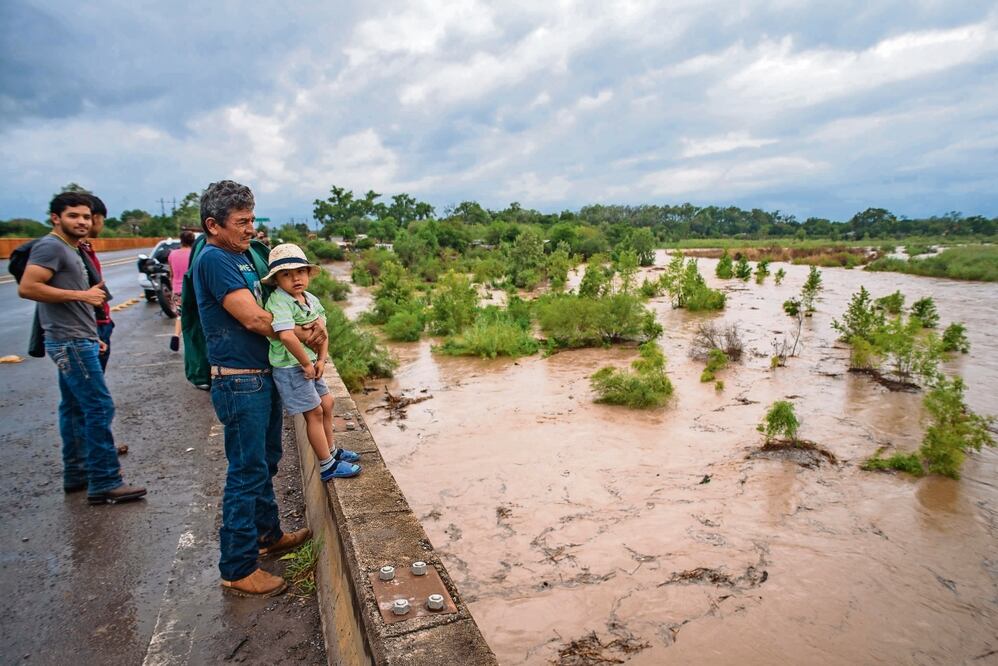Felices, decenas de personas acudieron al río Purificación para ver la creciente, entre ellos el señor Rodolfo León y su nieto, Gerardo. Foto: Roberto Iván Aguilar | El Universal