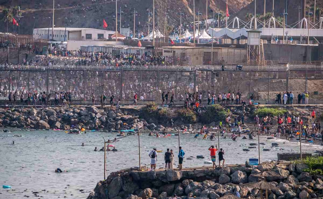 Migrants crowd together as they try to cross from Morocco into the Spanish enclave of Ceuta, Thursday, July 30, 2026. (AP Photo/Antonio Sempere)
