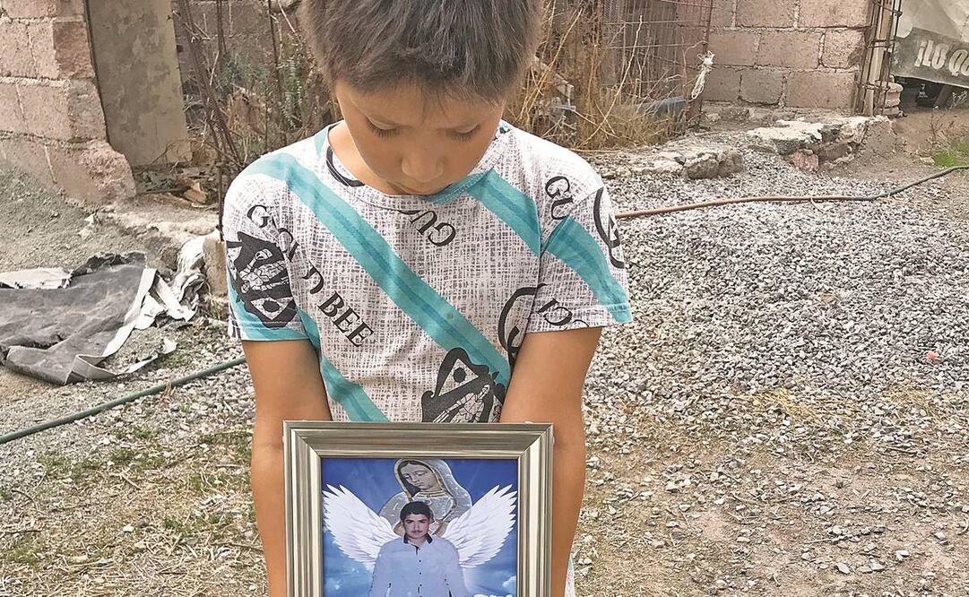 Gustavo, de nueve años, abraza la foto de su papá, quien falleció en un tráiler en Texas.