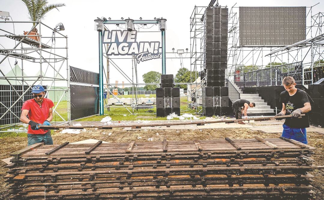 Trabajadores desmantelan el escenario tras la cancelación, el 10 de julio, del festival Live Again, en Erp, Países Bajos. Foto: EFE