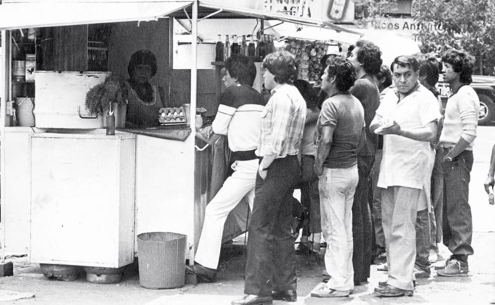 Grupo de aficionados de la Selección Mexicana viendo el encuentro México vs. Bélgica en un puesto de tortas, 3 de junio de 1986. Según reportó este diario, era común que negocios ambulantes tuvieran un cúmulo de personas a su alrededor si tenían una televisión sintonizando con el partido, aunque pocos eran los que consumían algo. Foto: Archivo EL UNIVERSAL.