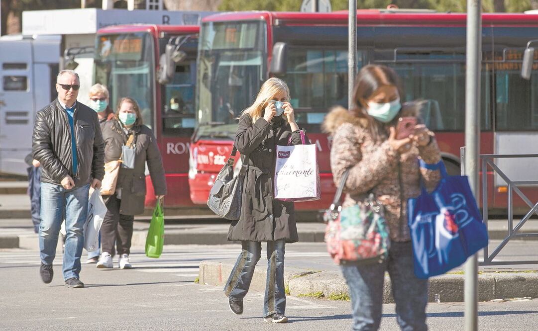 Italianos, con cubrebocas, en la estación de Roma Termini, en Roma. El gobierno decretó el cierre de todos los comercios, bares y restaurantes. Foto: MASSIMO PERCOSSI. EFE