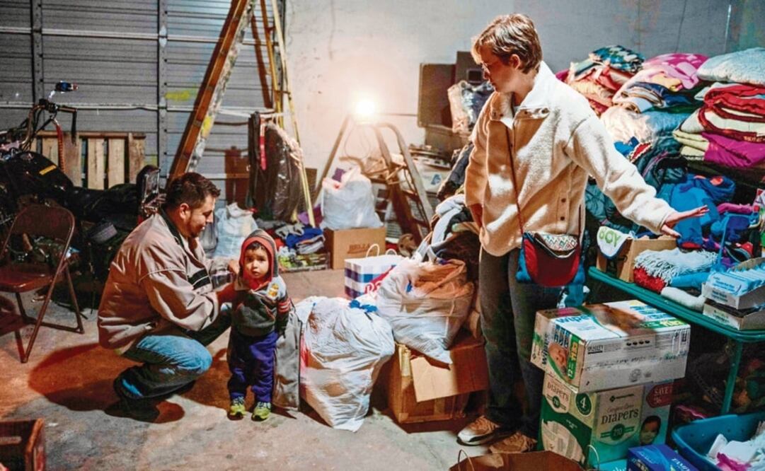 Augusto Mendoza y su hijo Dillon, de Guatemala, reciben ropa y comida de voluntarios en El Paso. Después de pasar cinco días en detención migratoria en Nuevo México, irá a Carolina del Norte. (PAUL RATJE. AFP)