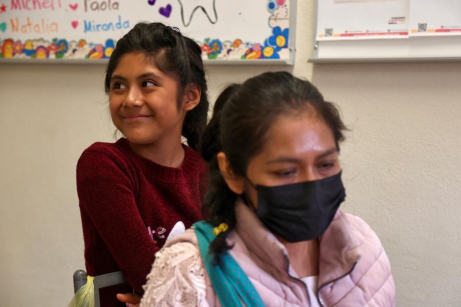 Jimena sonríe detrás de su madre mientras escuchan el diagnóstico de la odontóloga de la fundación. El costo de esta consulta fue de $10 pesos.