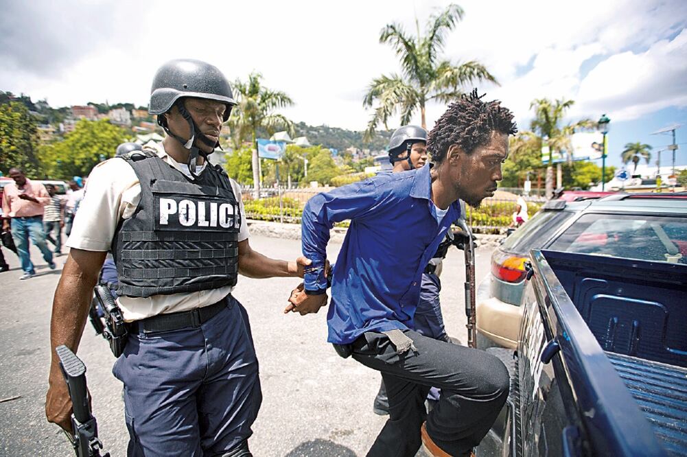 Un haitiano es detenido por la policía, tras ser acusado de votar dos veces en Puerto Príncipe, en las primeras elecciones parlamentarias del país en 4 años (DIEU NALIO CHERY. AP)