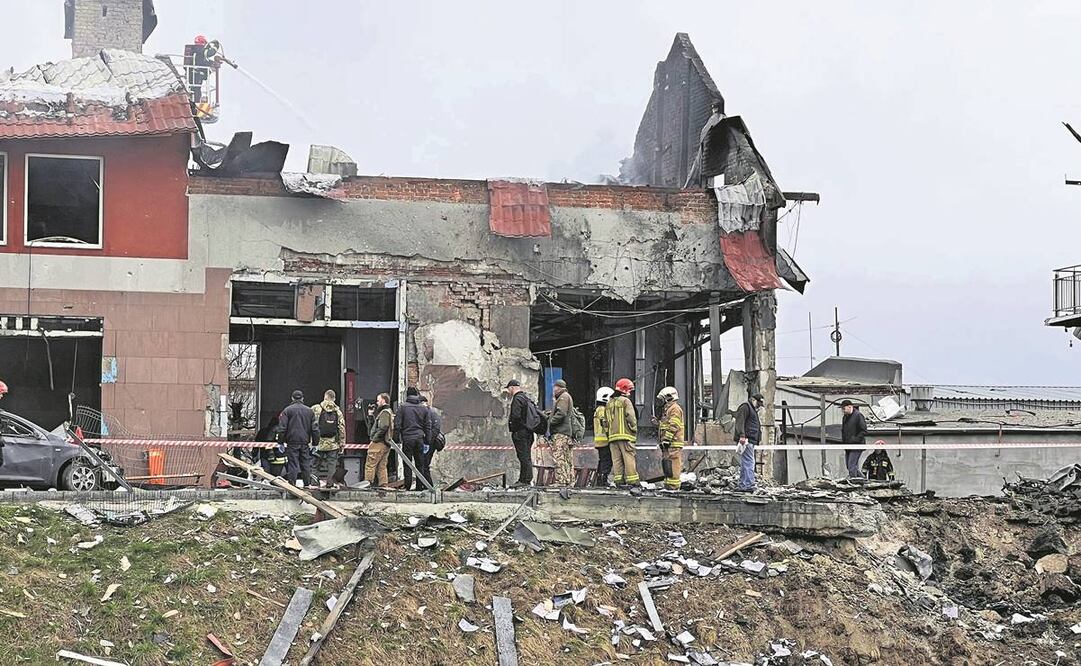 Equipos de emergencia limpian los escombros después de que un ataque aéreo golpeó una tienda de neumáticos en Lviv. Foto: Philip Crowther/ AP.