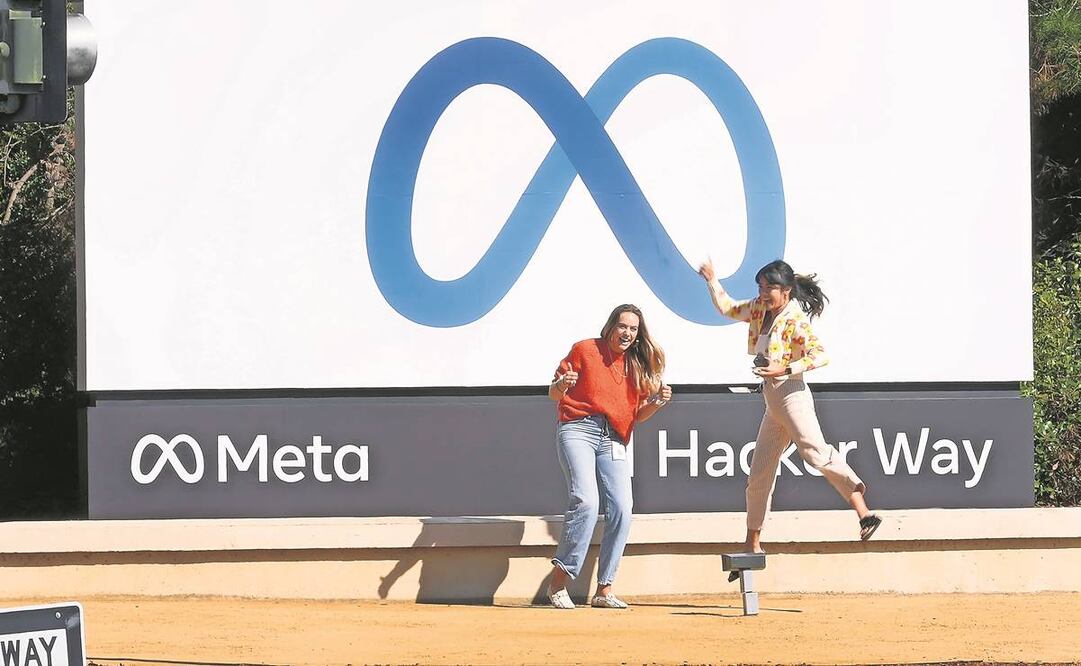 Colaboradores de Facebook se retratan junto al nuevo logo afuera de las oficinas centrales en Menlo Park, California, luego de que la compañía anunciara el cambio de nombre a Meta Platforms Inc. Foto: Tony Avelar/ AP.