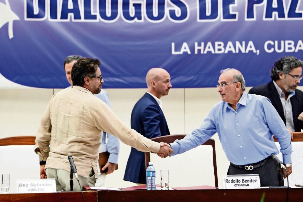 El comandante de las FARC y líder del equipo negociador de paz, Iván Márquez (izq.), con el jefe negociador del gobierno colombiano, Humberto de la Calle (ERNESTO MASTRASCUSA. EFE)