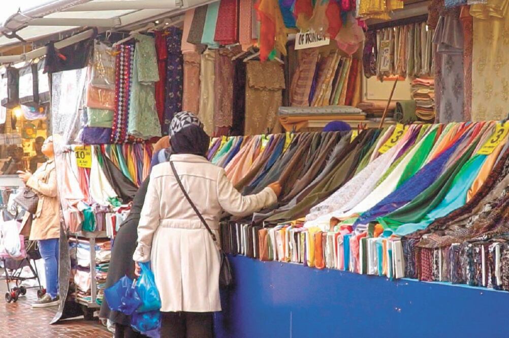 Afectadas. Mujeres musulmanas observan varias telas en un puesto de una calle, en La Haya. Foto: IMANE RACHIDI. EFE