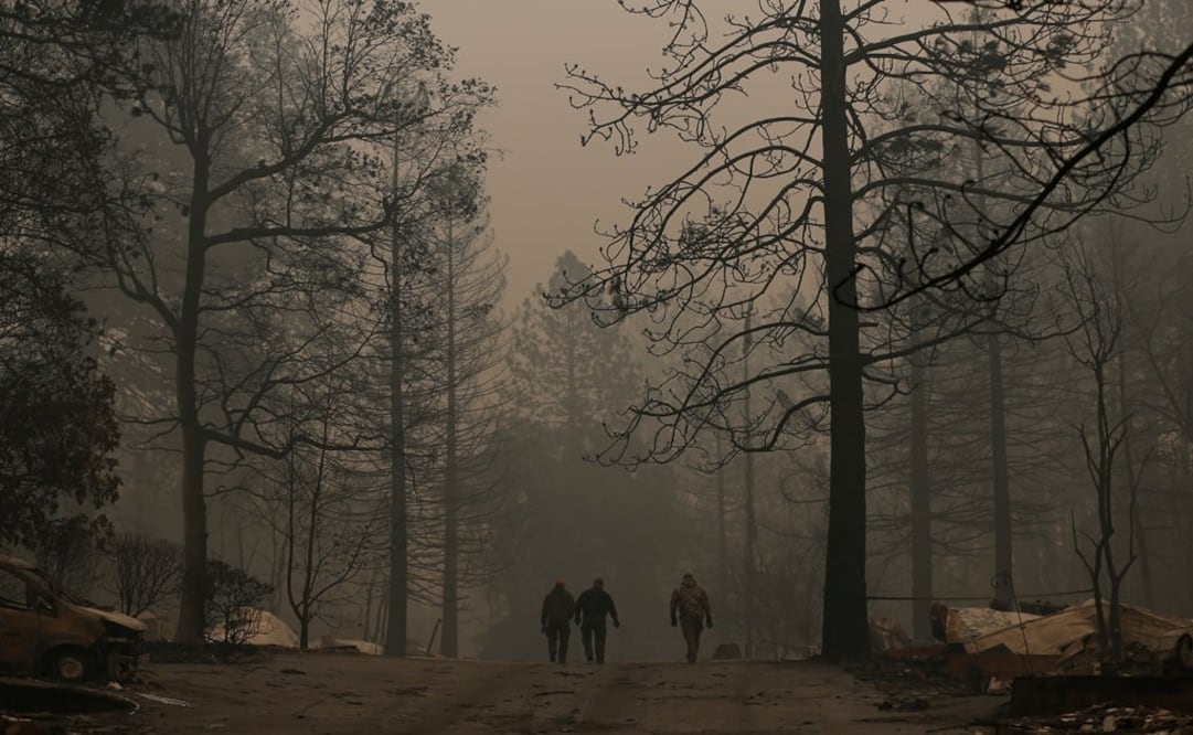 Yuba and Butte County Sheriff deputies walk on a street after recovering a deceased victim during the Camp fire in Paradise, California, U.S. - Photo: Stephen Lam/REUTERS