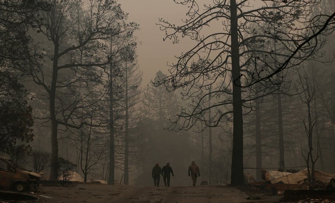 Yuba and Butte County Sheriff deputies walk on a street after recovering a deceased victim during the Camp fire in Paradise, California, U.S. - Photo: Stephen Lam/REUTERS