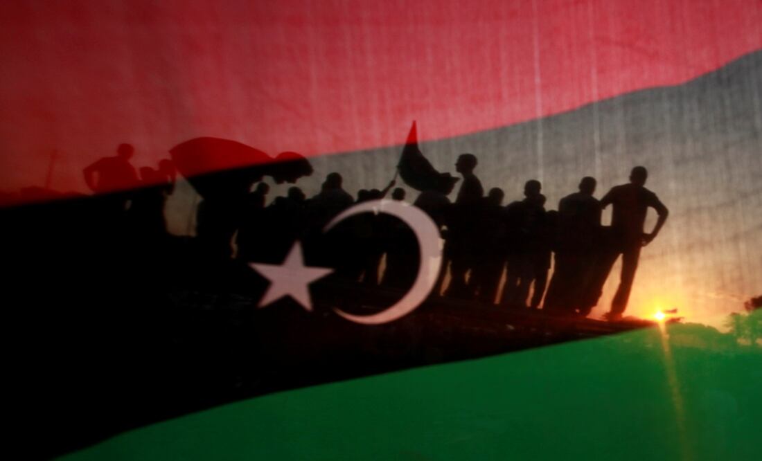 Libyans are seen through a Kingdom of Libya flag - Photo: Suhaib Salem/REUTERS