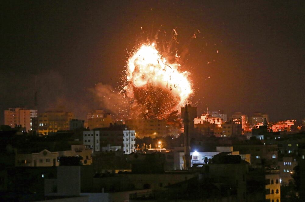 Una bola de fuego se observa sobre el edificio de la televisión dirigida por Hamas al-Aqsa TV en la ciudad de Gaza, tras el impacto de misiles israelíes. (BASHAR TALEB. AFP)