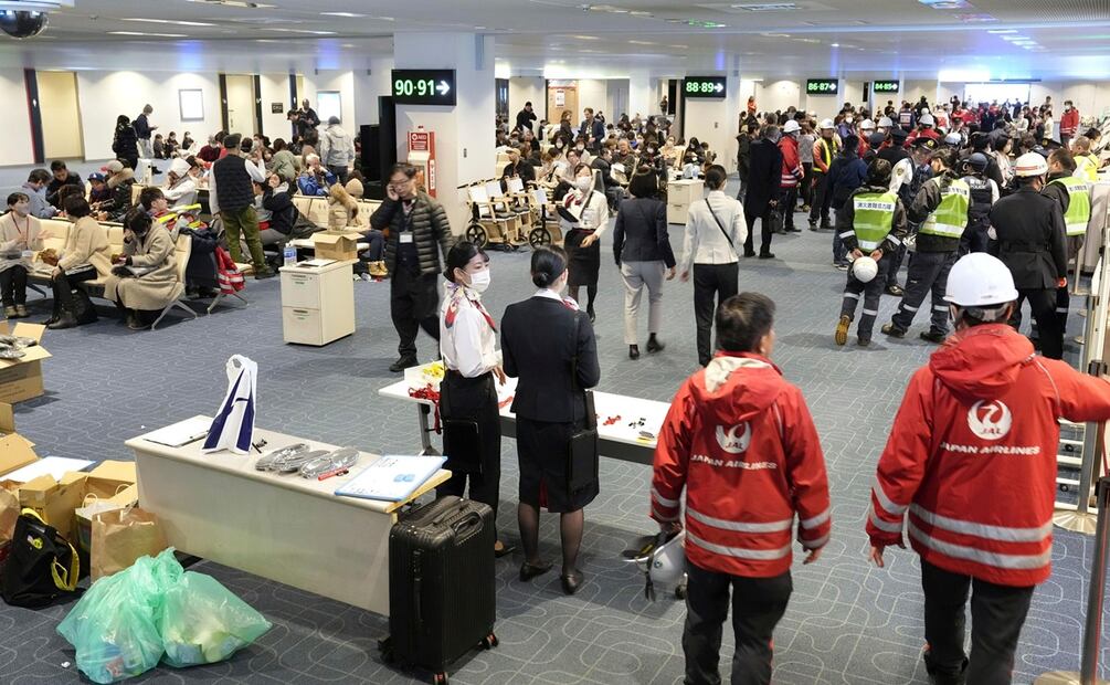 Los trabajadores de Japan Airlines esperan en el aeropuerto de Haneda el martes 2 de enero de 2024 en Tokio, Japón. Foto: AP