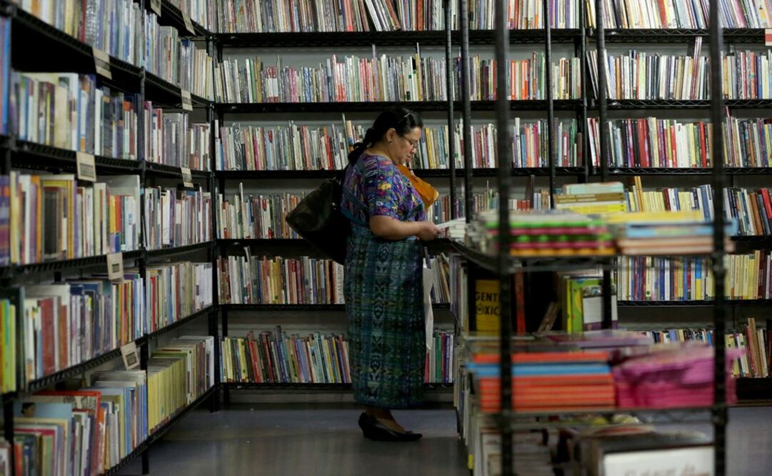 Mujer observando libros en la Feria Internacional del Libro de Guatemala. Foto: EFE/Esteban Biba