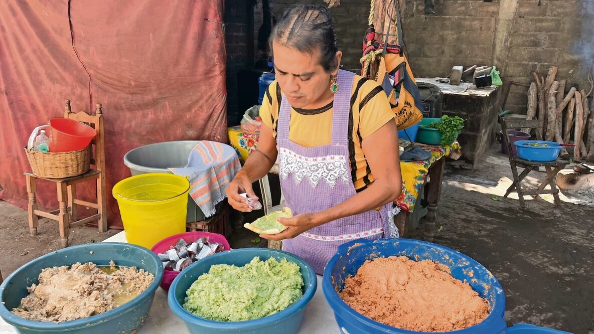 Paola tiene su cocina bajo un techo de lámina sostenido por macizos horcones de madera; ahí operan dos hornos de comiscal, dos fogones, tercios de leña y cuatro mesas. Foto:RUSVEL RASGADO