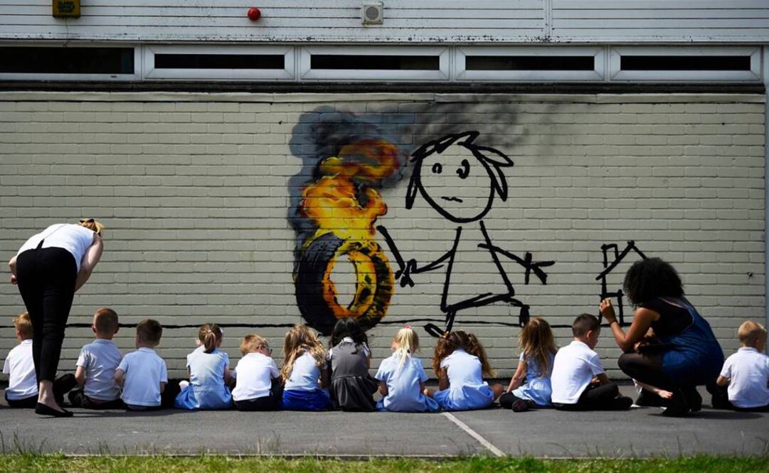 En la propuesta aparece la figura de una niña haciendo rodar un neumático incendiado y el artista invitó a los alumnos a hacerle modificaciones. (FOTOS: Reuters)