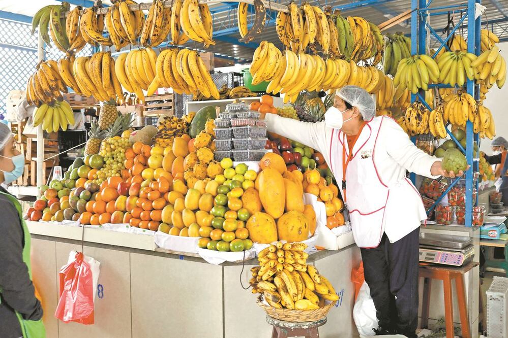 Una vendedora selecciona frutas en un puesto de un mercado, en Lima, Perú. De acuerdo con el IPE, el país sostiene una pérdida de 6.7 millones de empleos, producto de las crisis sanitaria y económica. MARIANA BAZO. AFP