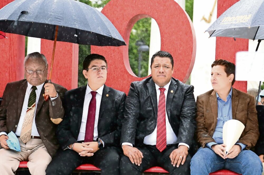 El diputado Paulo César Martínez (tercero de izq. a der.) se quedó sin paraguas y resignado a terminar empapado, mientras sus compañeros Luciano Tlacomulco, José Briones y Arturo Núñez se cubrían de la lluvia (BERENICE FREGOSO. EL UNIVERSAL)