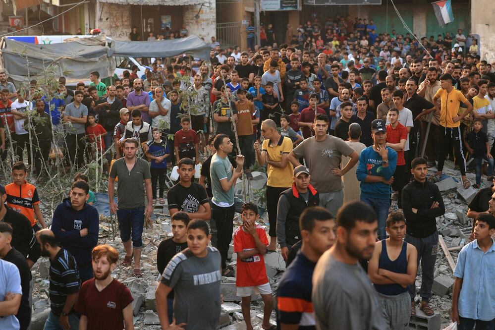 Los palestinos observan mientras los rescatistas intentan encontrar supervivientes y víctimas entre los escombros tras un ataque del ejército israelí en Khan Yunis, en el sur de la Franja de Gaza. Foto: AFP