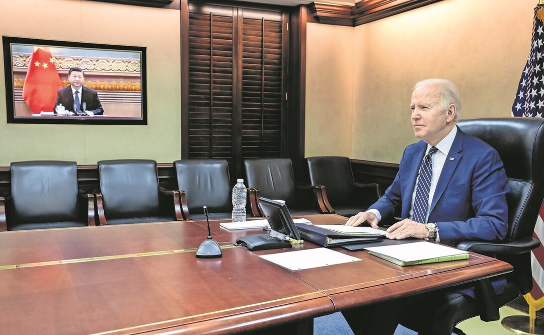 El presidente de Estados Unidos, Joe Biden (der.), mientras habla con su homólogo chino, Xi Jinping (en pantalla), durante una reunión virtual desde su oficina en Washington. Según experto, el reto está en la capacidad de Beijing de poner sobre la mesa un
