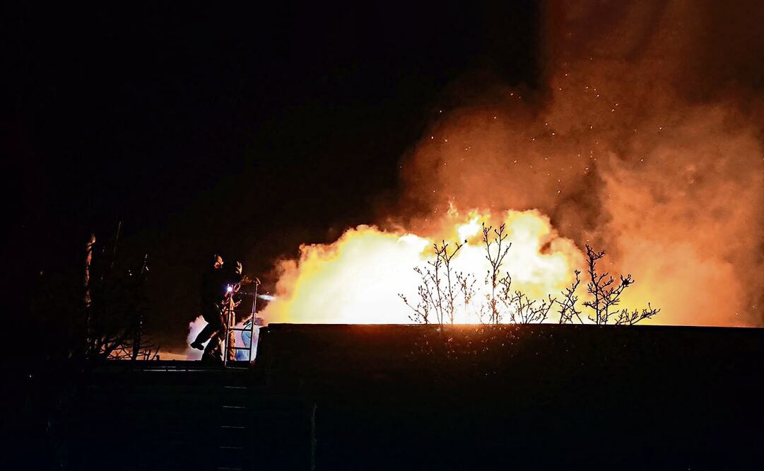 Los bomberos ucranianos al trabajar después de un ataque aéreo en Dnipro, en medio de la invasión rusa a Ucrania. Foto: AFP