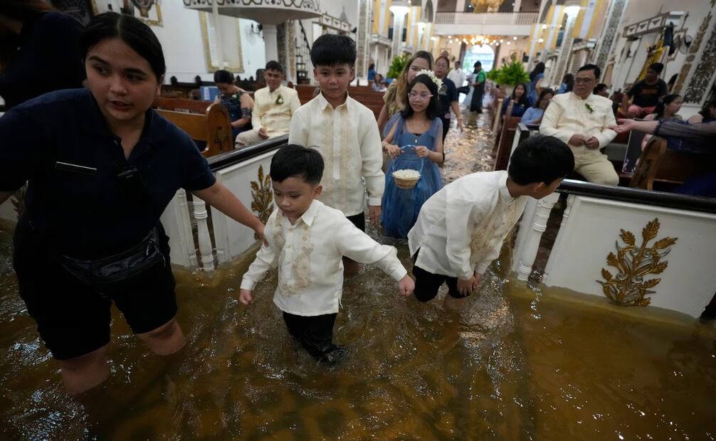 Varios invitados de la boda caminaron en la iglesia inundada. Foto: Aaron Favila (AP)