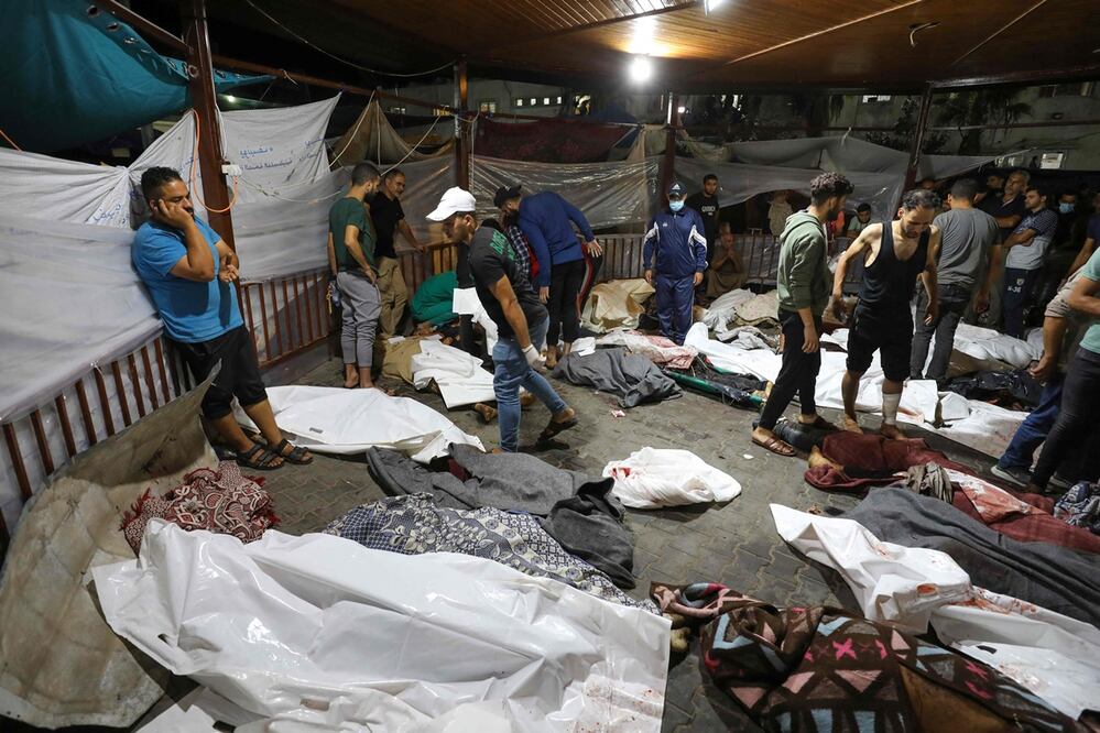 Personas reunidas alrededor de los cuerpos de palestinos muertos en ataques aéreos israelíes contra el hospital árabe Ahli en el centro de Gaza. Foto: AFP