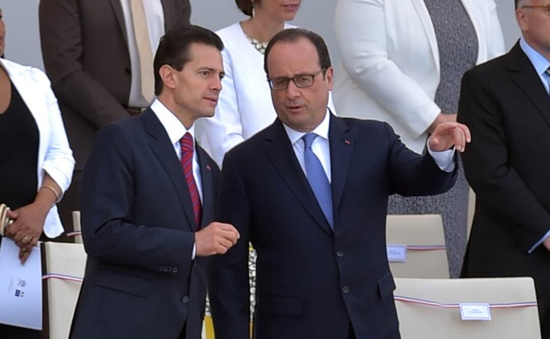 El presidente mexicano Enrique Peña Nieto, conversando con el presidente francés Francois Hollande, durante el desfile militar por el Día Nacional de Francia, en la Plaza de la Concordia en París Foto: Xinhua
