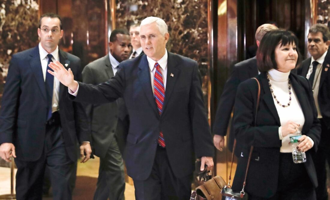 El vicepresidente electo, Mike Pence, acompañado por su esposa Karen, saluda a la prensa a su salida de la Trump Tower, ayer en Nueva York. (FOTO: CAROLYN KASTER. AP)