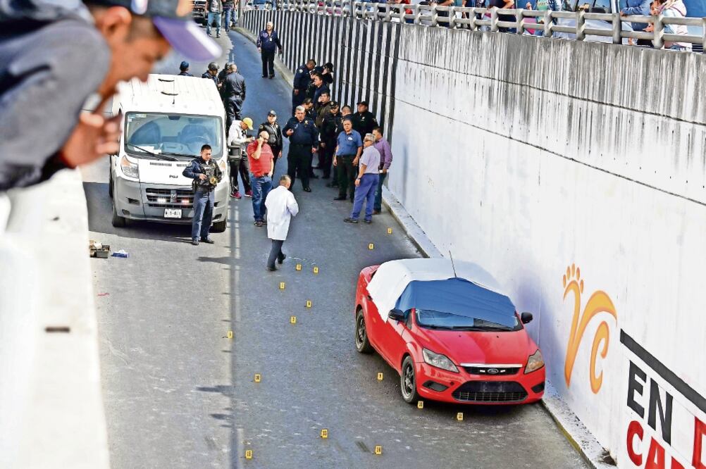 Alrededor del auto Ford Focus de color rojo, sin placas, peritos encontraron al menos 15 casquillos percutidos de diferentes calibres; la circulación se vio afectada por el levantamiento del cuerpo y los indicios balísticos (ARMANDO MARTÍNEZ. EL UNIVERSA)