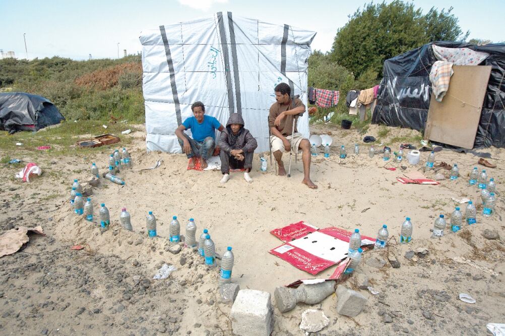 Migrantes en una mezquita improvisada, en un campamento ubicado cerca de Calais, al norte de Francia (EMILIO MORENATTI. AP)