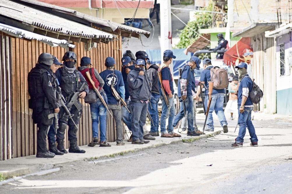 Violencia. Imagen de autodefensas, luego de que se enfrentaran contra presuntos grupos criminales, lo que dejó un saldo de siete muertos, en Filo de Caballos. (EFE)