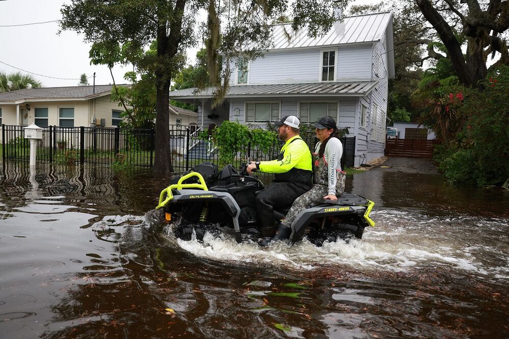 La gente monta un ATV a través de las calles inundadas causadas por el huracán Idalia pasando mar adentro en Tarpon Springs, Florida. FOTO: AFP