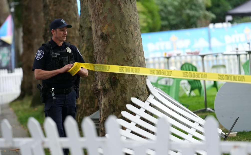 Un agente de la policía de Seattle coloca cinta policial en el lugar de un tiroteo en el Seattle Center durante el festival gastronómico Bite of Seattle el domingo 26 de julio de 2026. Foto: AP/Lindsey Wasson