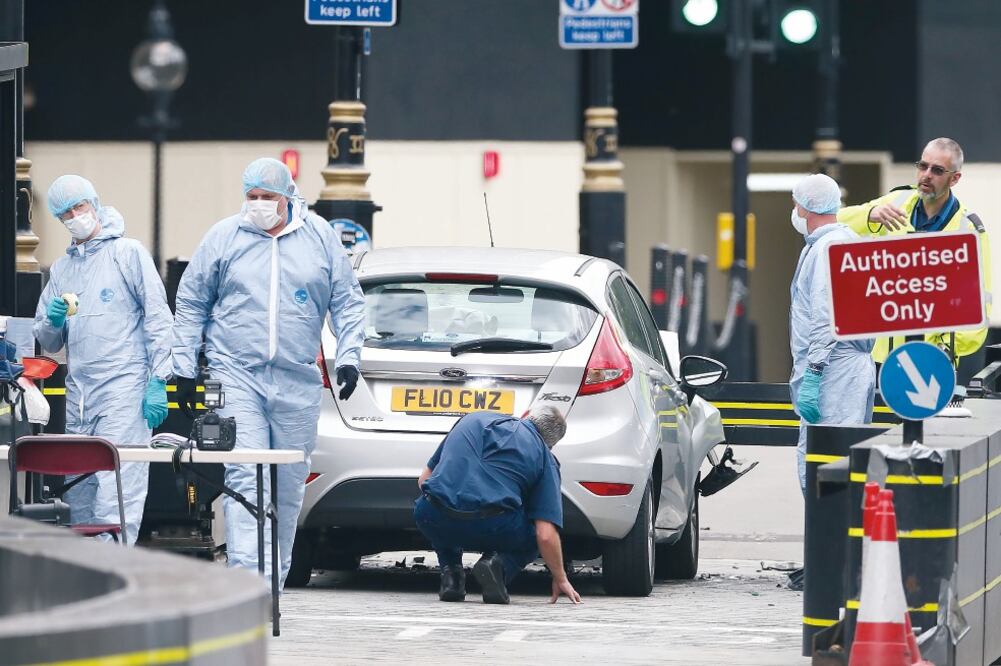Investigadores trabajan en la zona donde un auto se estrelló contra las barreras de seguridad del palacio de Westminster. (DANIEL LEAL-OLIVAS. AFP)