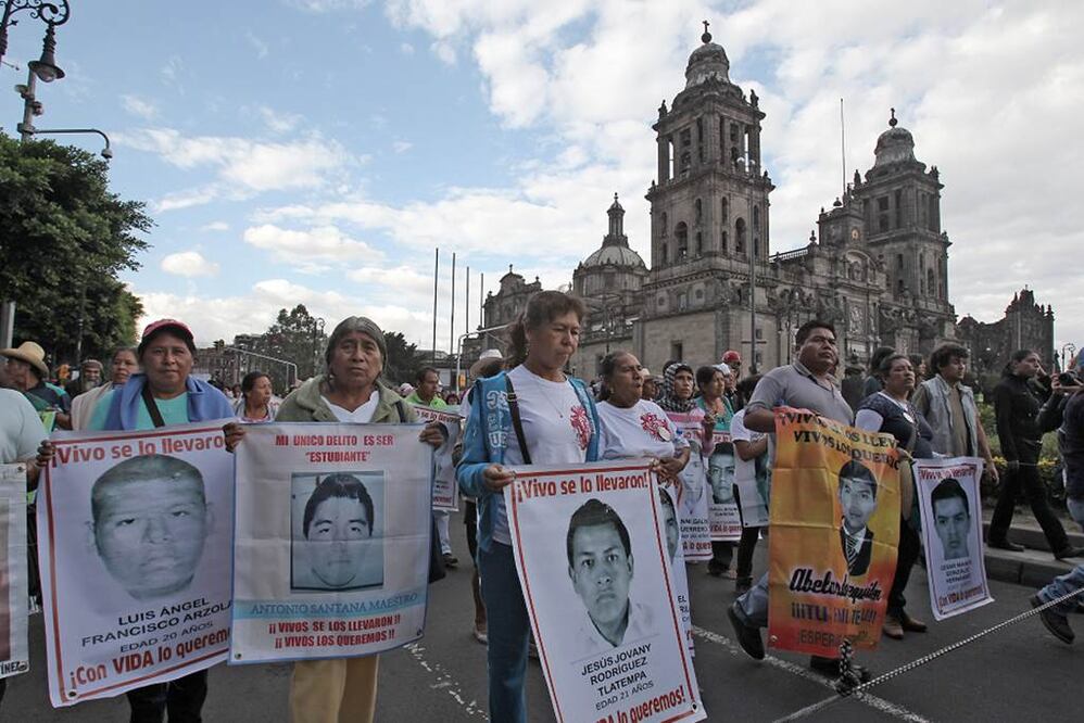En la foto, familiares y compañeros de los 43 estudiantes desaparecidos hace 11 meses (EFE)