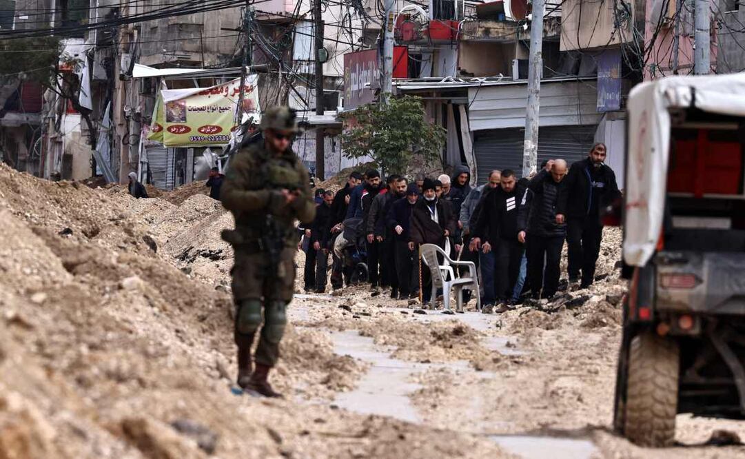 Soldados israelíes vigilan cómo los palestinos abandonan sus hogares en busca de seguridad durante una redada del ejército en el campo de refugiados de Nur Shams, cerca de Tulkarem, en la ocupada Cisjordania, el 10 de febrero de 2025. Foto: AFP