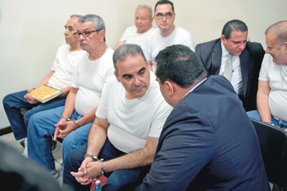El ex presidente de El Salvador, Elías Antonio Saca (Centro), habla con su abogado mientras espera su sentencia (MARVIN RECINOS. AFP)