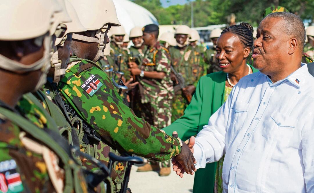 El primer ministro haitiano, Garry Conille (derecha), y la exministra de Asuntos Exteriores keniana, Monica Juma, saludan a agentes de policía de Kenia en su base en el barrio de Clercine de Puerto Príncipe. Foto: Clarens Siffroy | AFP