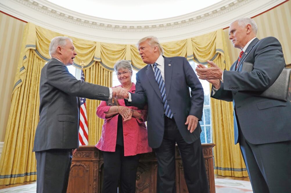 El presidente de Estados Unidos, Donald Trump, estrecha la mano de Jeff Sessions (izq.) en señal de felicitación, después de que el vicepresidente Mike Pence (der.) le tomó protesta como fiscal general del país, tras su ratificación (PABLO MARTINEZ. AP)