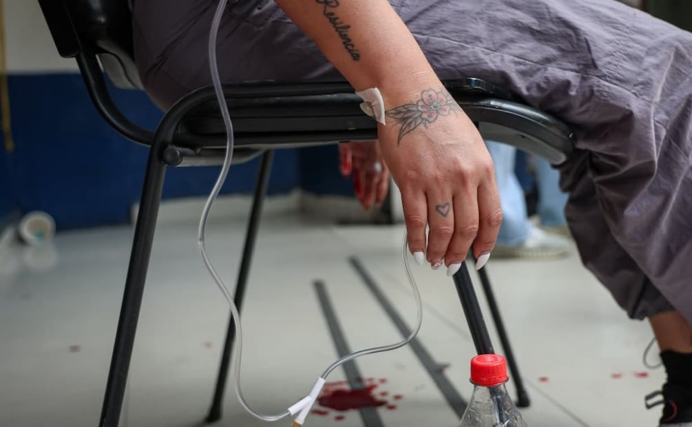 La mujer se colocó catéteres en ambos brazos con los que se sacó sangre en los escalones del búnker. | Foto. Luis Camacho / El Universal.