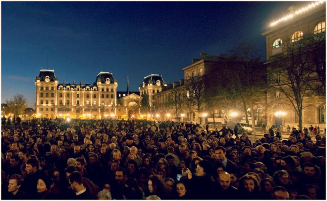 La gente se reunió en homenaje a las víctimas de los ataques la noche del domingo afuera de la Catedral de Notre Dame