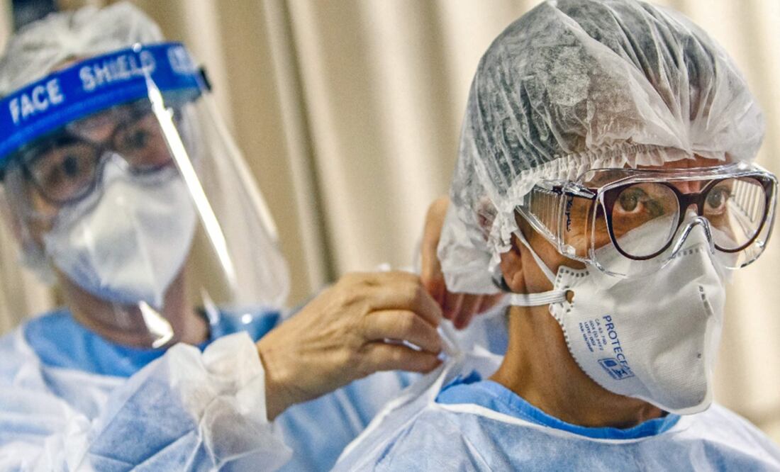 A doctor puts a face mask on a colleague before treating patients infected with the novel coronavirus - Photo: Silvio Ávila/AFP
