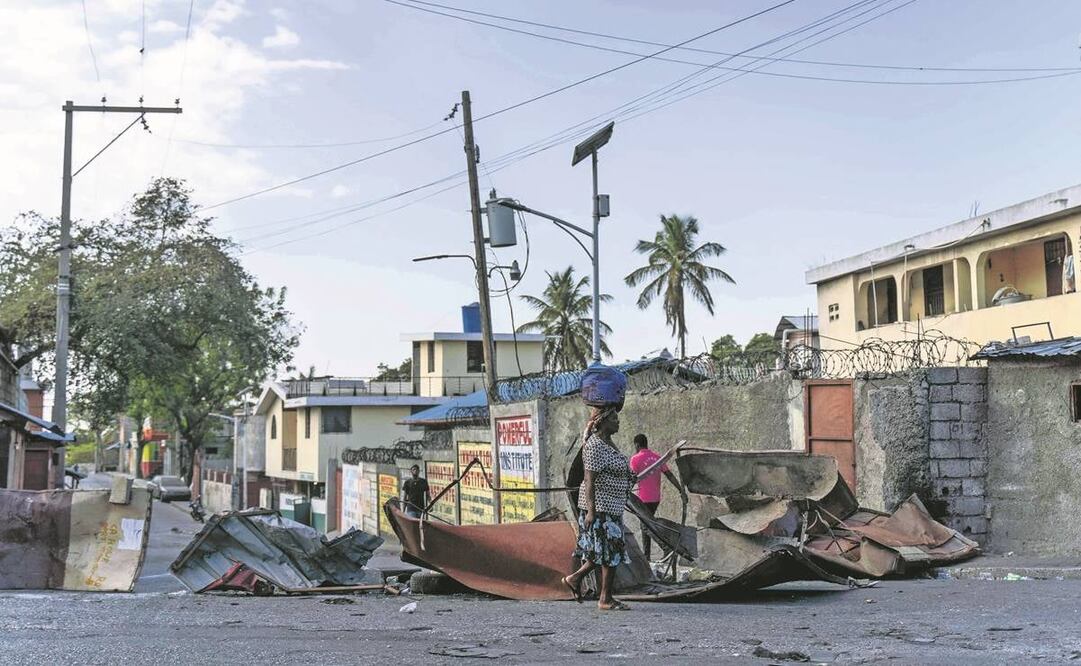 Una haitiana, frente a una carretera bloqueada en medio de la violencia de bandas en Puerto Príncipe. Foto: Richard Pierrin/ AFP