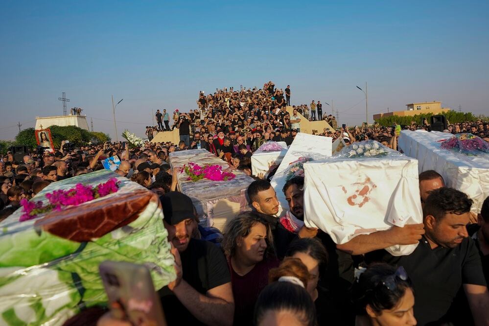 Amigos y familiares asisten al funeral de las personas que murieron en un incendio durante la ceremonia de una boda en Hamdaniya, Irak. FOTO: AP