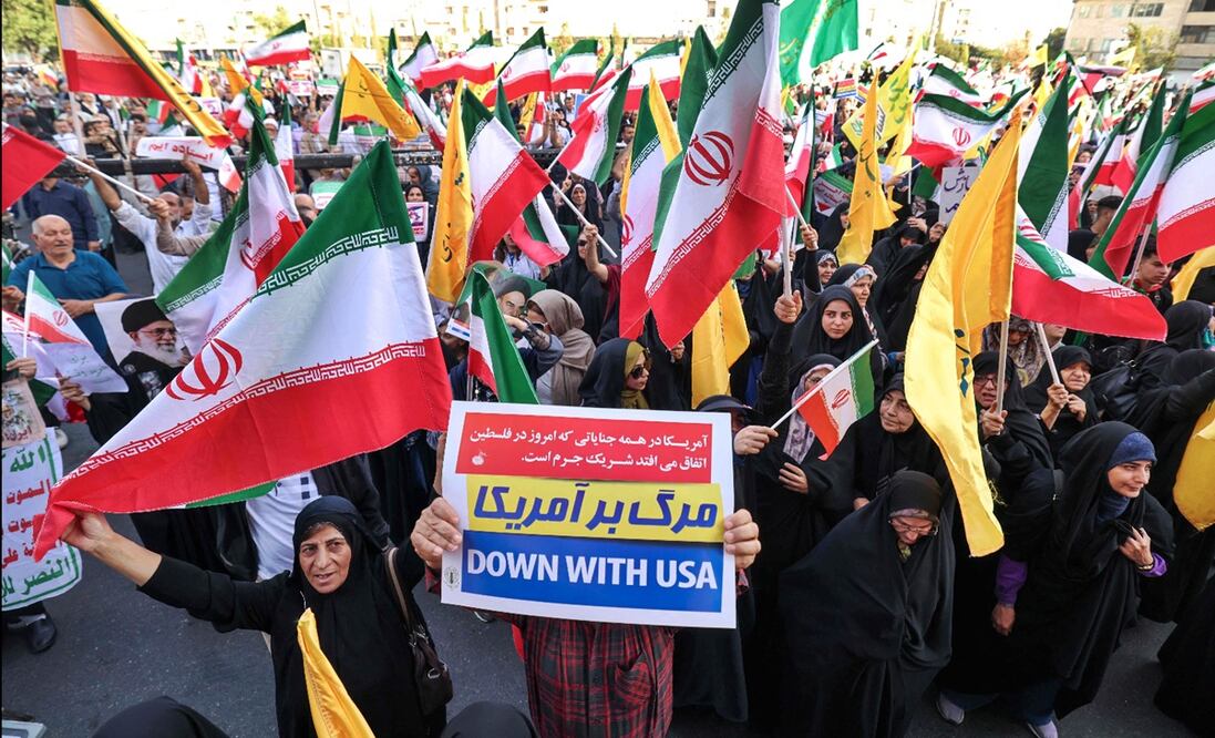 Iraníes ondean banderas nacionales y corean consignas mientras celebran el alto el fuego entre Irán e Israel en la plaza Enghlab en Teherán, el 24 de junio de 2025. Foto: AFP