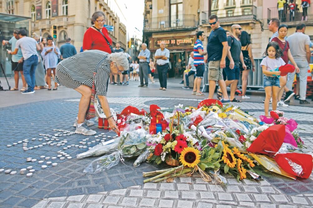 Una mujer coloca flores en un altar en memoria de las víctimas del atentado en Las Ramblas, en Barcelona, con motivo del primer aniversario del ataque, ocurrido el 17 de agosto de 2017. Foto: MANU FERNANDEZ. AP
