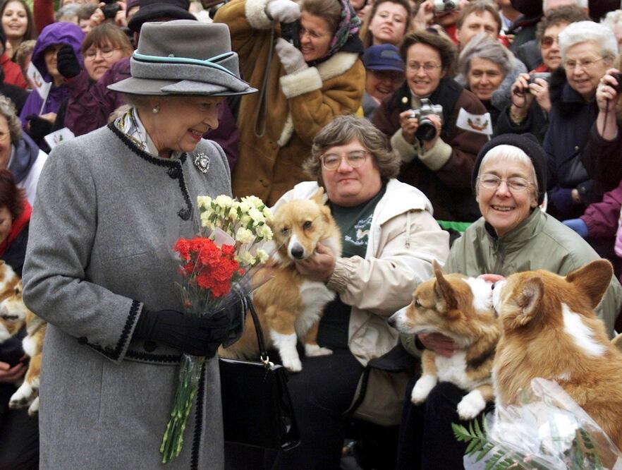 La reina Isabel II habla con miembros de la Asociación Manitoba de Corgis, durante una visita a Winnipeg, en 2002. AP